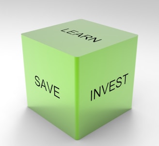 A green 3D cube with the words 'LEARN', 'SAVE', and 'INVEST' on its visible sides, set against a plain white background.